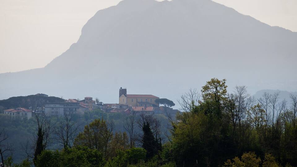 A mountain with a church and buildings on a hillside.