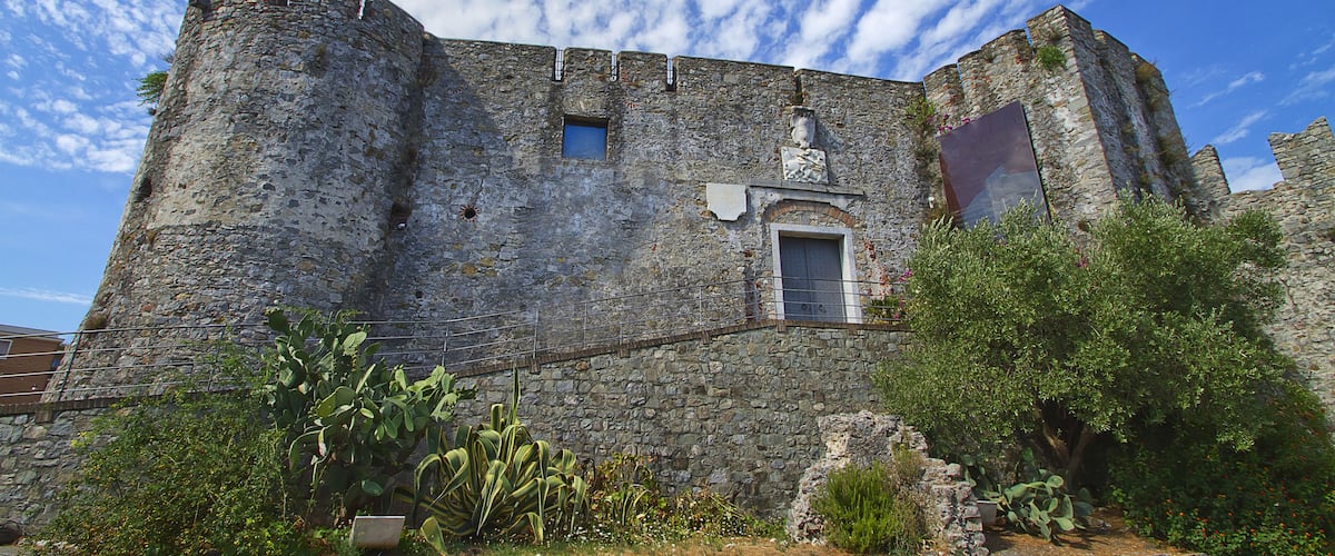 A historic stone castle with a round tower, a small window, and a door.