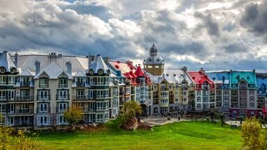 Colorful buildings with a prominent tower and a green park in the foreground.