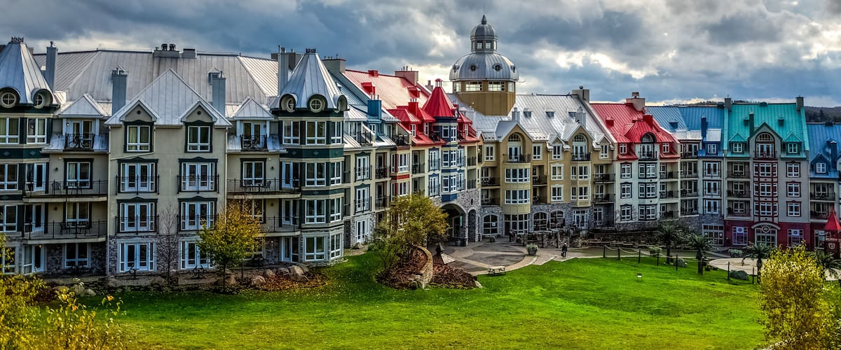 Colorful buildings with a prominent tower and a green park in the foreground.