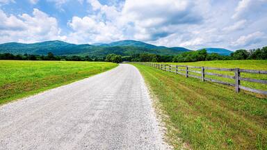 Farm road fence in Roseland, Virginia near Blue Ridge parkway mountains in summer with idyllic rural landscape countryside in Nelson County