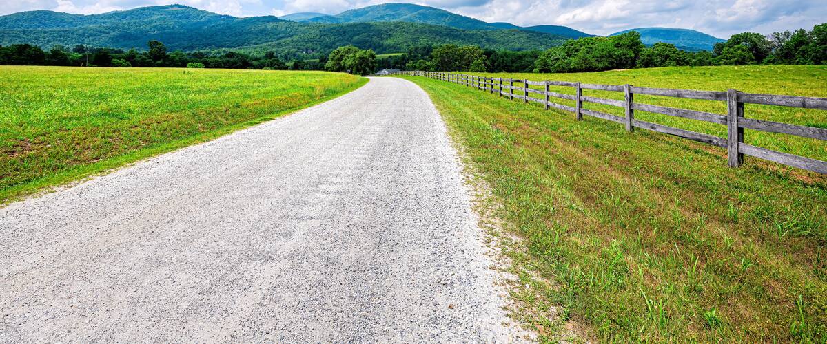 Farm road fence in Roseland, Virginia near Blue Ridge parkway mountains in summer with idyllic rural landscape countryside in Nelson County