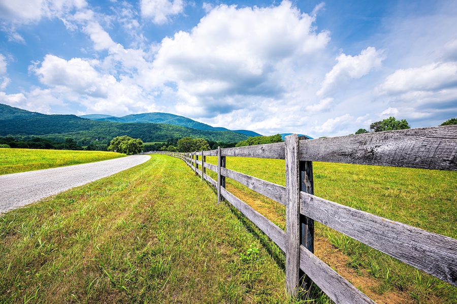 Farm road fence closeup in Roseland, Virginia near Blue Ridge parkway mountains in summer with idyllic rural landscape countryside in Nelson County