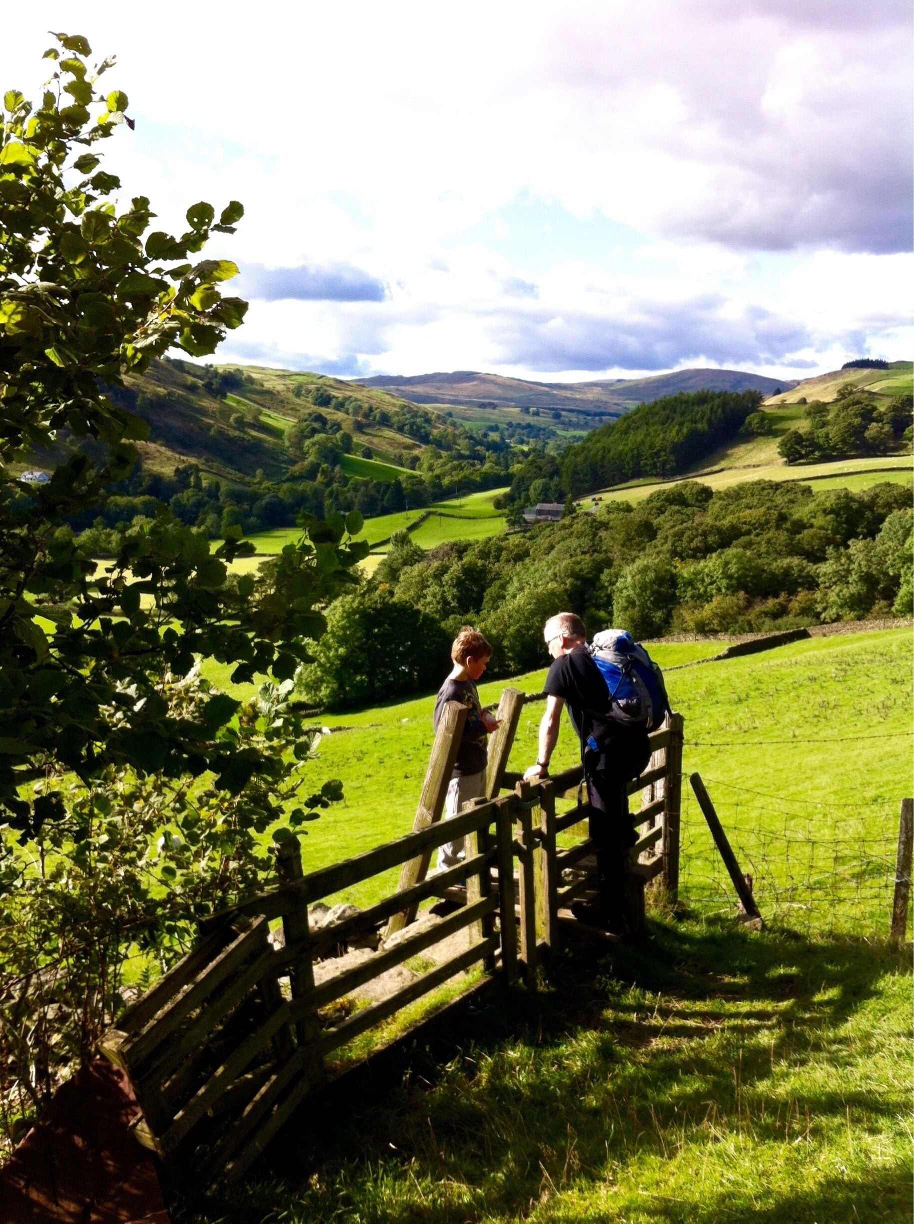 A rural landscape with rolling hills, a wooden fence, and a valley.