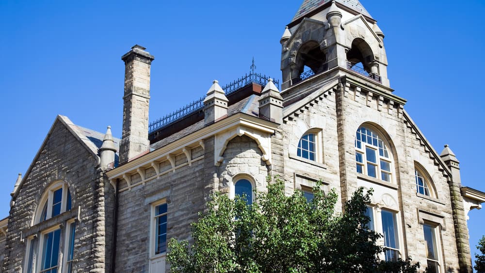A historic stone building with arched windows and a bell tower.