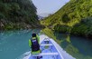 TAMUL, SAN LUIS POTOSI MEXICO - January 6, 2020: Rear view of man in raincoat and vest rowing in canoe. Active, adventure, outdoors, in tamul river