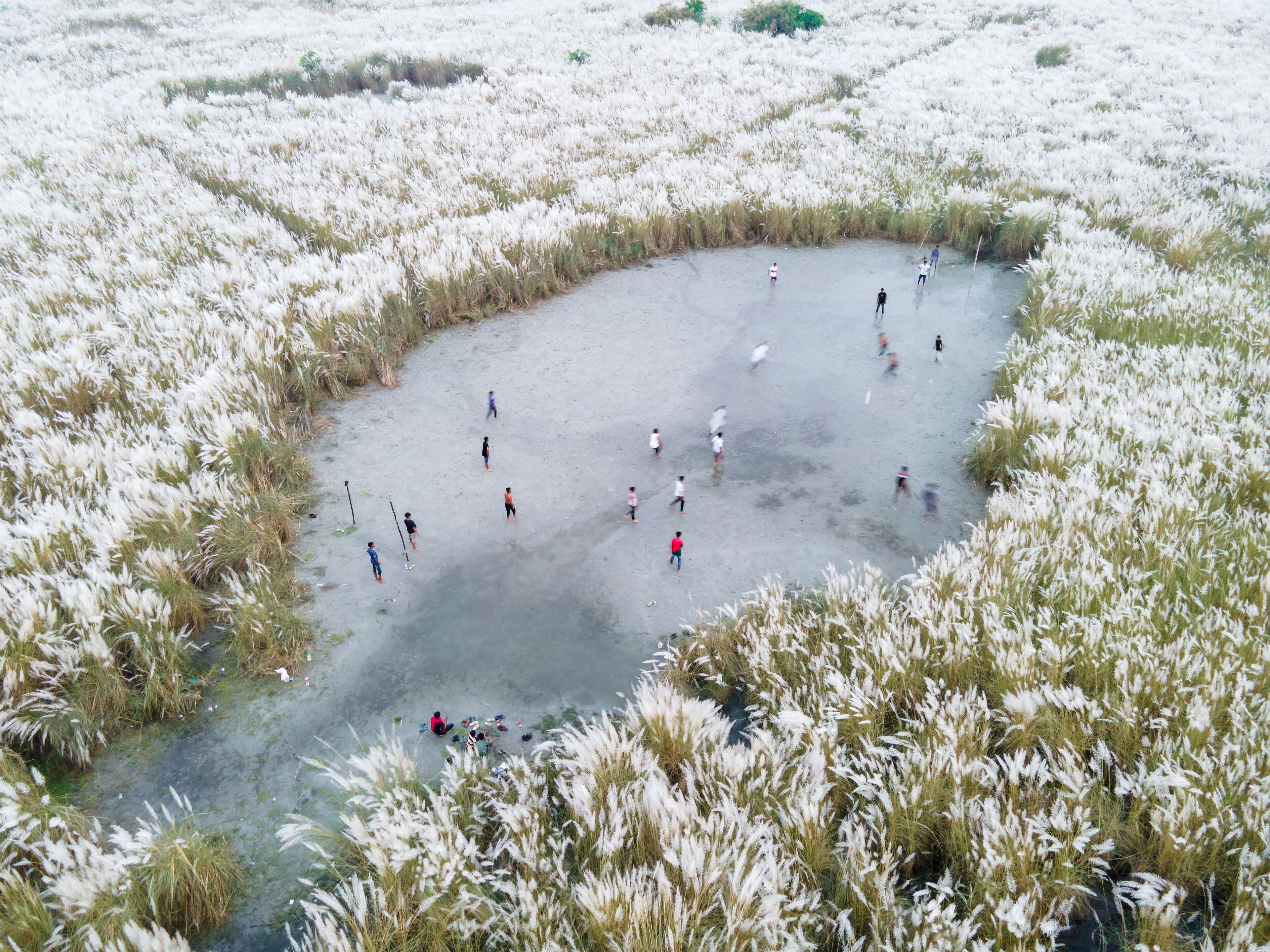  Aerial view of boys playing soccer on a permanent sand field surrounded by temporary flower beds in the capital city Dhaka, Bangladesh.