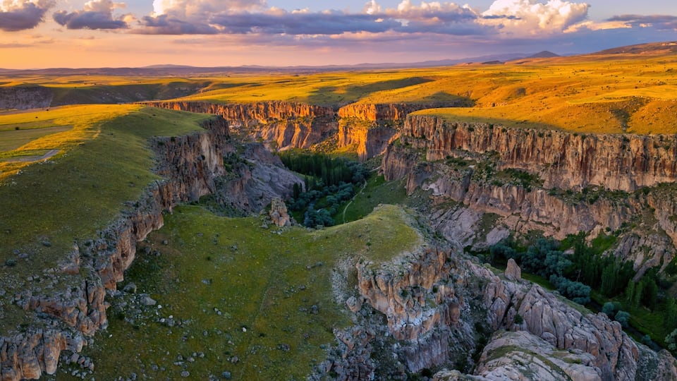 A canyon with steep cliffs and a river running through it.