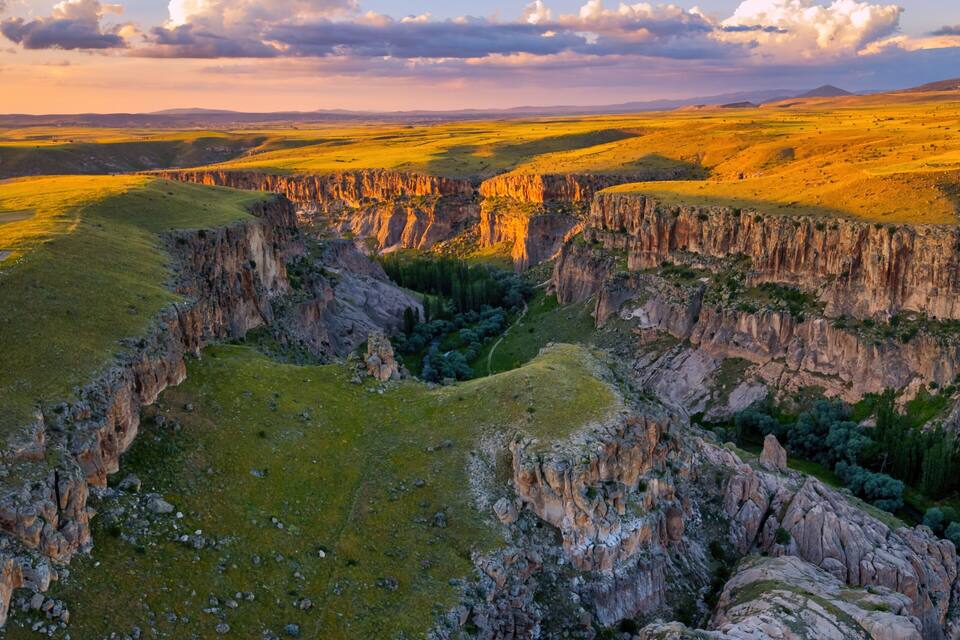 A canyon with steep cliffs and a river running through it.
