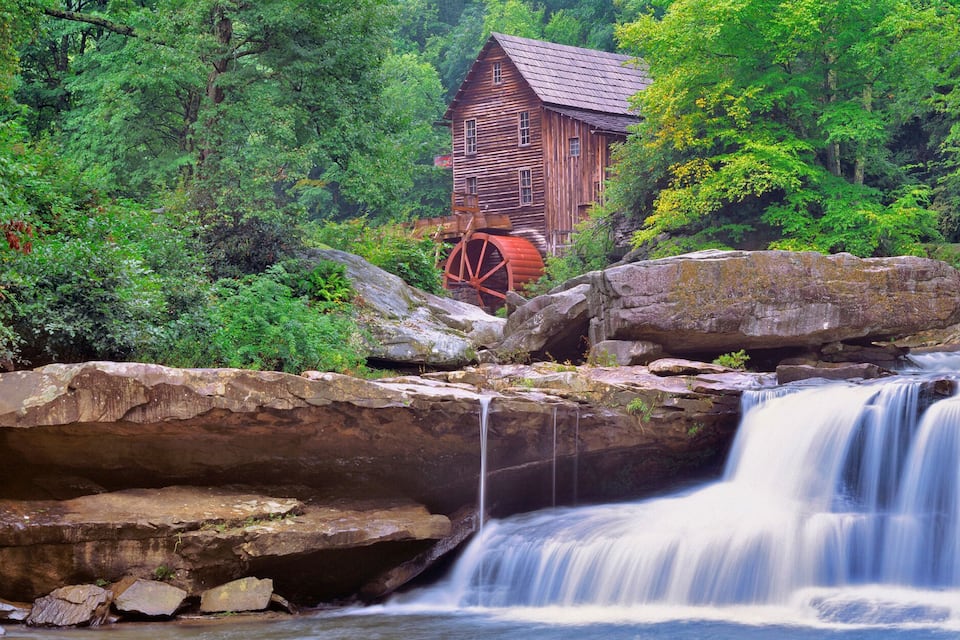 A waterfall with a wooden structure in a forested area.