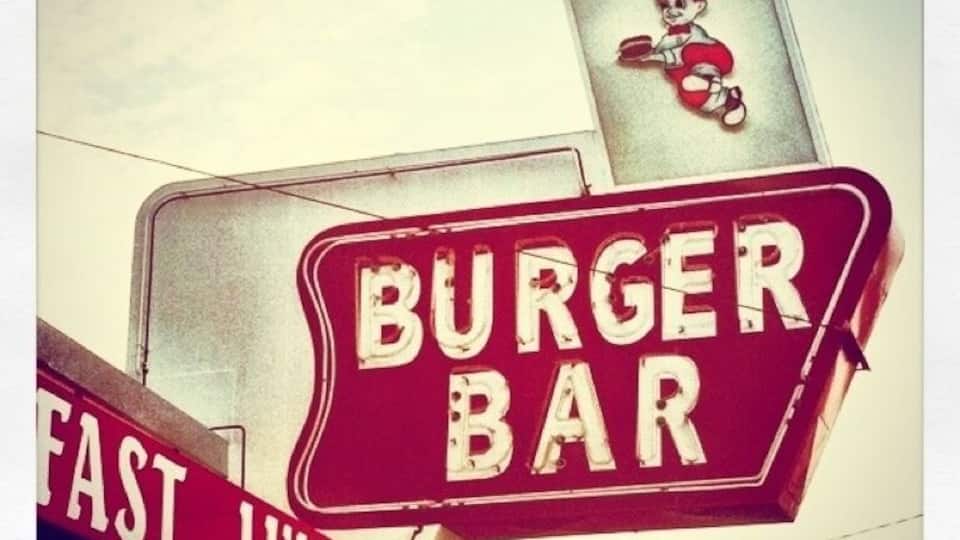 A burger bar sign with a child illustration.