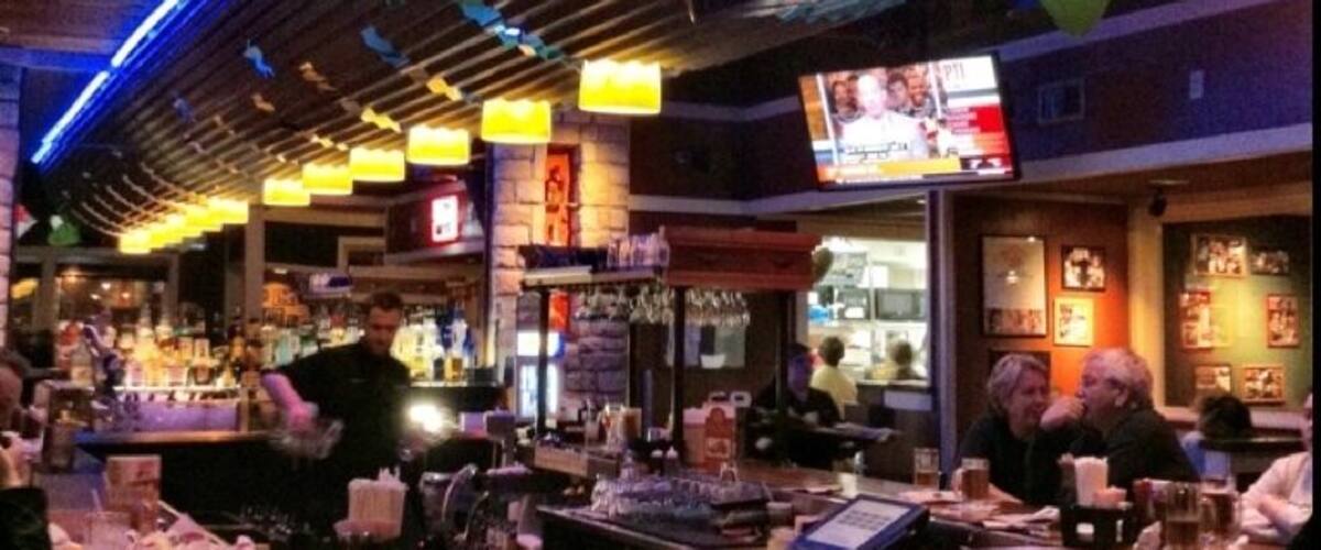 A bar with a neon sign reading "Chips Margarita Bar".