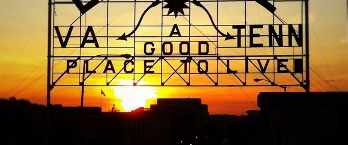 When the Bristol Gas and Electric Company was purchased in 1910 the new owners donated this advertising sign. The “Mammoth Electric Sign”, measuring 60’ wide by 35’ high, was shipped by rail and dedicated on July 4 to a crowd of over 3,000 citizens. For its first five years it was perched on the top of The Interstate Hardware building until it was removed in 1915 to its present location over State Street. The original slogan read, “Push, That’s Bristol”, which was the mantra for the era’s industrial “push” that centered in Bristol. In 1921 the polish of the sign had diminished Bristol’s marketing icon when its lights would flicker “PU” That’s Bristol or “SH” that’s Bristol, and a citywide campaign chose its current slogan. In 1988 it was accepted to the National Register of Historical Places.
In 2010 this enormous structure, the Bristol Slogan Sign, marked its 100th year on the eastern end of downtown Bristol, itself straddling State Street. It has been a part of community pride and the one structure in the city that has identified Bristol’s common purpose and heritage. The message on this sign has been the marketing slogan for the city for close to 90 of those years, and considered one of the oldest community slogans in the United States. It reads, “Bristol Va – Tenn, A Good Place To Live”.