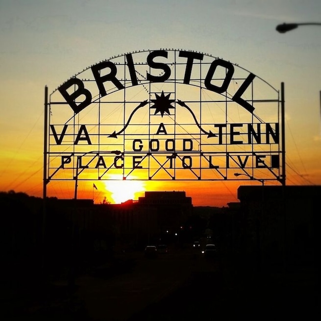 When the Bristol Gas and Electric Company was purchased in 1910 the new owners donated this advertising sign. The “Mammoth Electric Sign”, measuring 60’ wide by 35’ high, was shipped by rail and dedicated on July 4 to a crowd of over 3,000 citizens. For its first five years it was perched on the top of The Interstate Hardware building until it was removed in 1915 to its present location over State Street. The original slogan read, “Push, That’s Bristol”, which was the mantra for the era’s industrial “push” that centered in Bristol. In 1921 the polish of the sign had diminished Bristol’s marketing icon when its lights would flicker “PU” That’s Bristol or “SH” that’s Bristol, and a citywide campaign chose its current slogan. In 1988 it was accepted to the National Register of Historical Places.
In 2010 this enormous structure, the Bristol Slogan Sign, marked its 100th year on the eastern end of downtown Bristol, itself straddling State Street. It has been a part of community pride and the one structure in the city that has identified Bristol’s common purpose and heritage. The message on this sign has been the marketing slogan for the city for close to 90 of those years, and considered one of the oldest community slogans in the United States. It reads, “Bristol Va – Tenn, A Good Place To Live”.