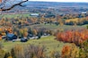 A country home is nestled amongst the Autumn colours as seen from Rattlesnake Point Conservation Area near Milton, Ontario.