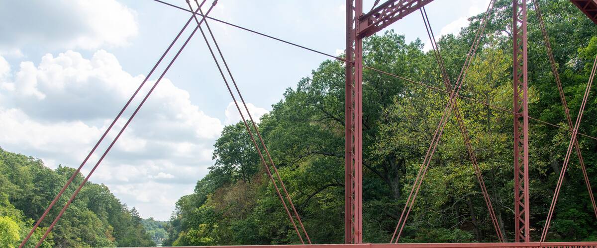 New Milford, CT, USA-August 2022; View over the Housatonic River from the wrought-iron Lover's Leap Bridge, a lenticular truss bridge in Lovers Leap State Park open only for foot traffic
