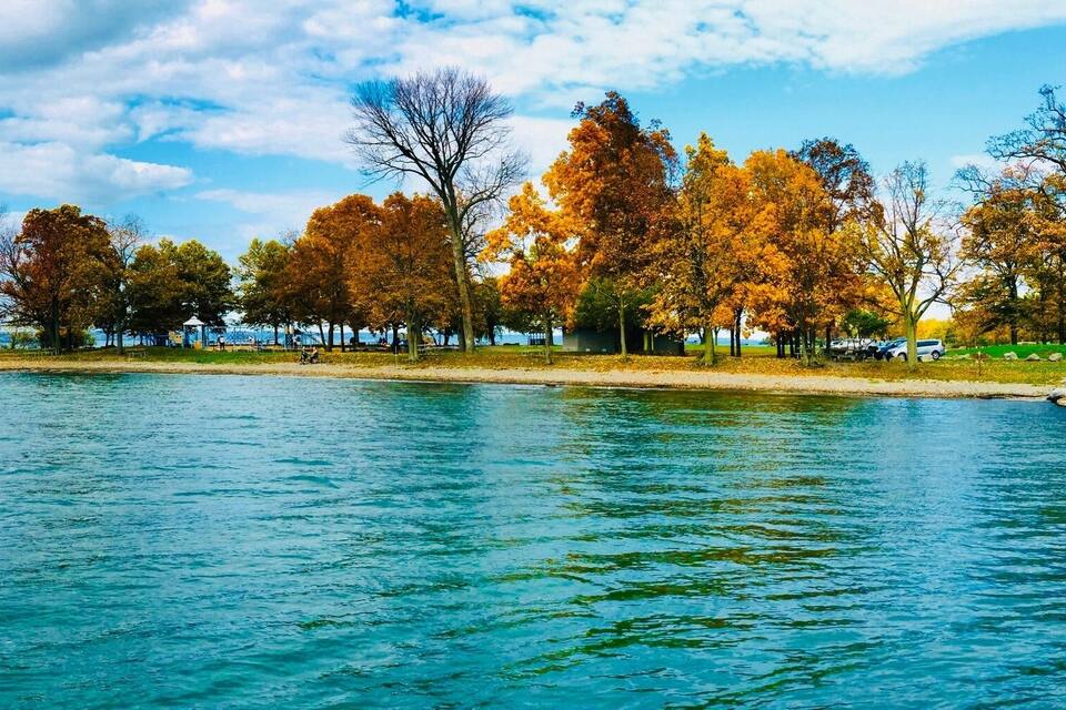 A lake with autumn-colored trees and a rocky shoreline.