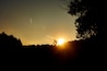 A silhouette of a person on a bicycle against a sunset.