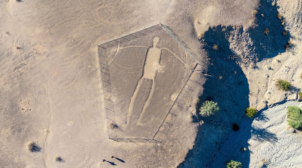 Blythe Intaglios Aerial View – Main Human Geoglyph, California Desert. Ancient desert figure near Blythe with visible erosion channel approaching fence, showing natural wear over time.