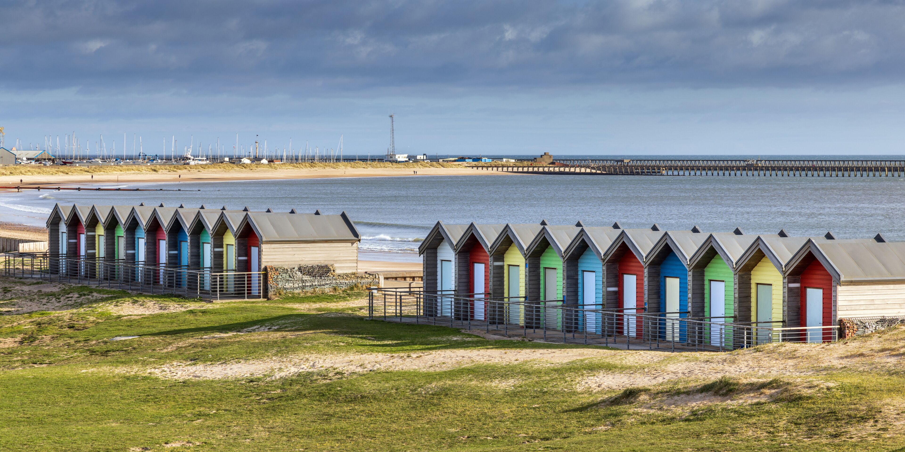 Line of colourful British beach huts at Blythe, Northumberland on the Northumbria Coast.