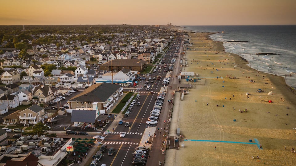 A coastal town with a beach, a pier, and a densely packed residential area.