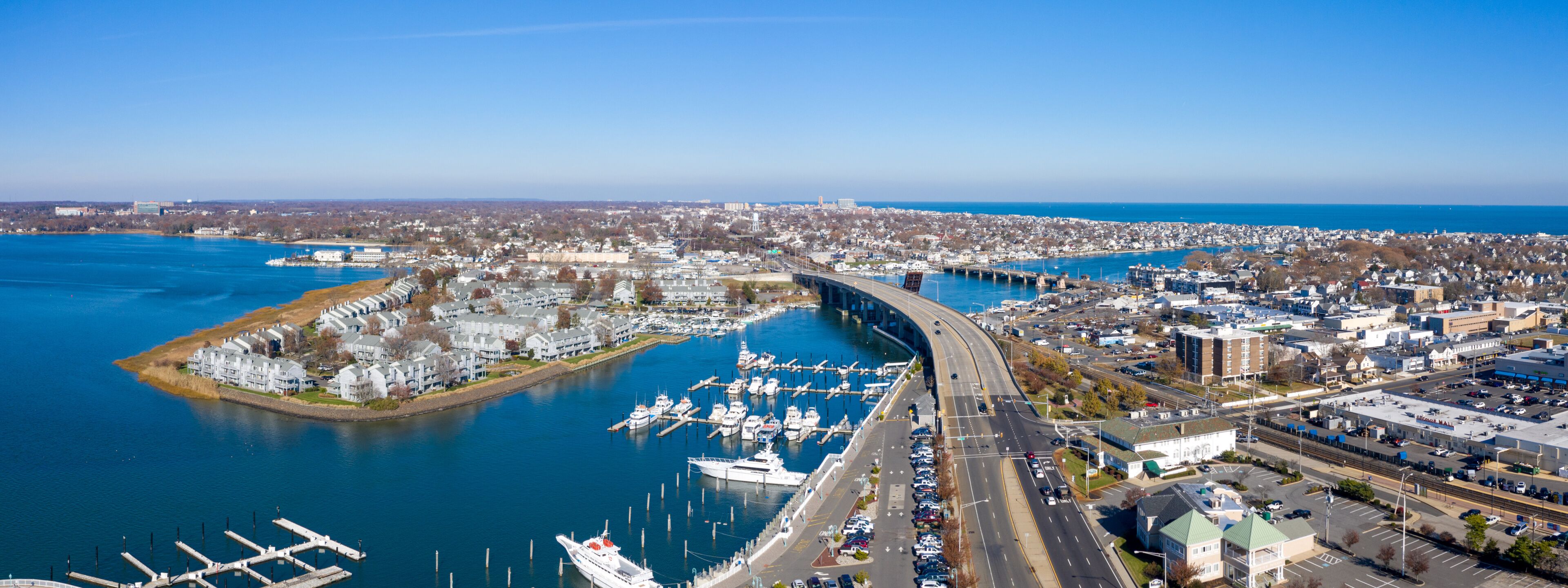 A coastal city with a marina, a bridge, and a dense urban area.