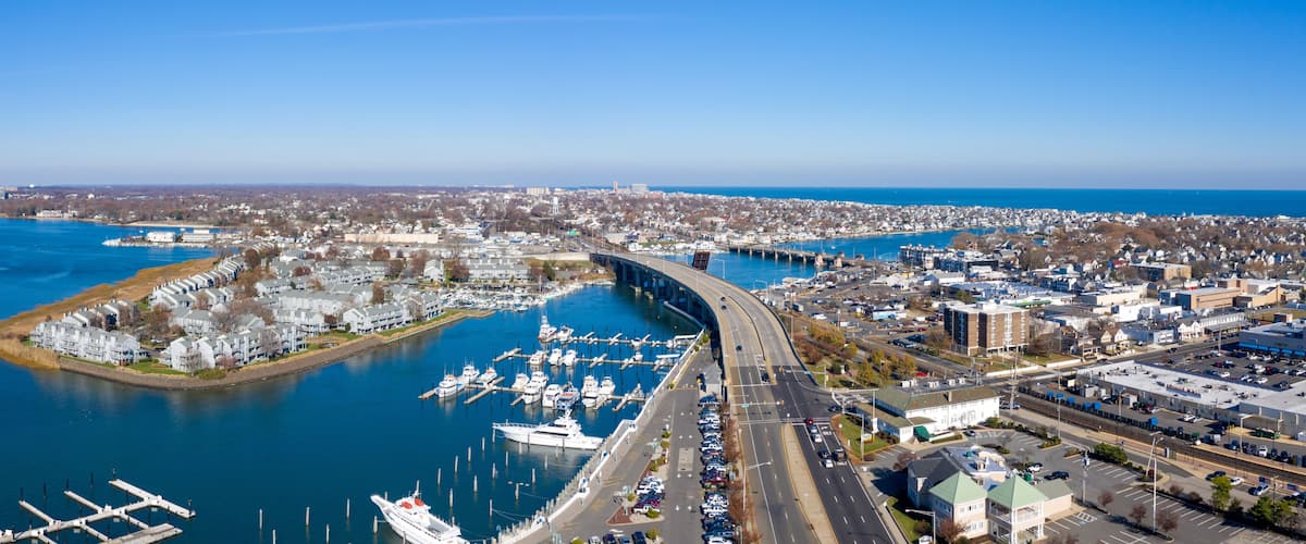A coastal city with a marina, a bridge, and a dense urban area.