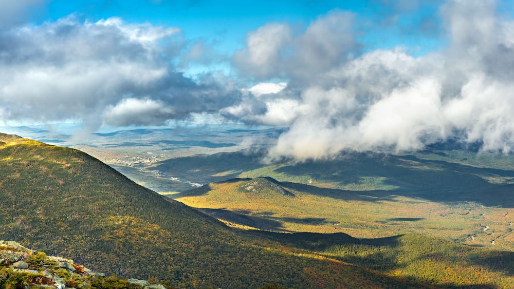 Un paysage montagneux, avec de vastes forêts et une vallée en contrebas.