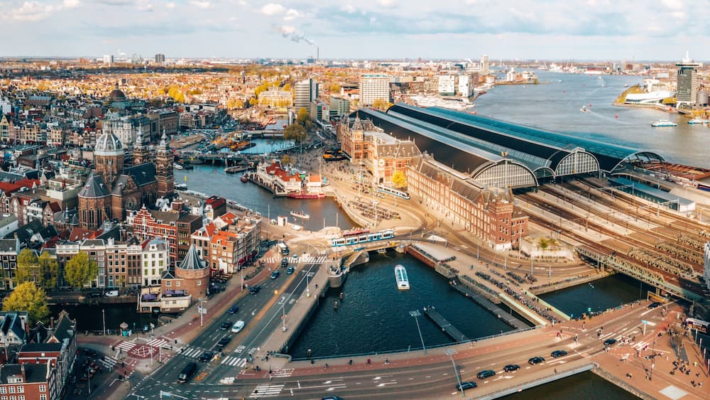 Beautiful aerial Amsterdam view from above with many narrow canals, streets and architectures.