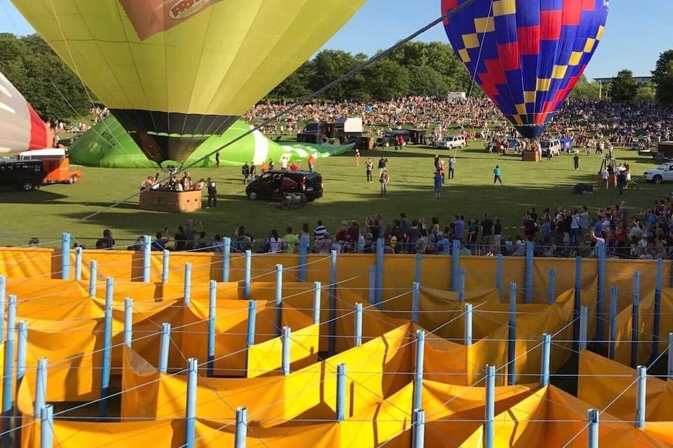 Een luchtballonfestival met kleurrijke ballonnen en een menigte toeschouwers.