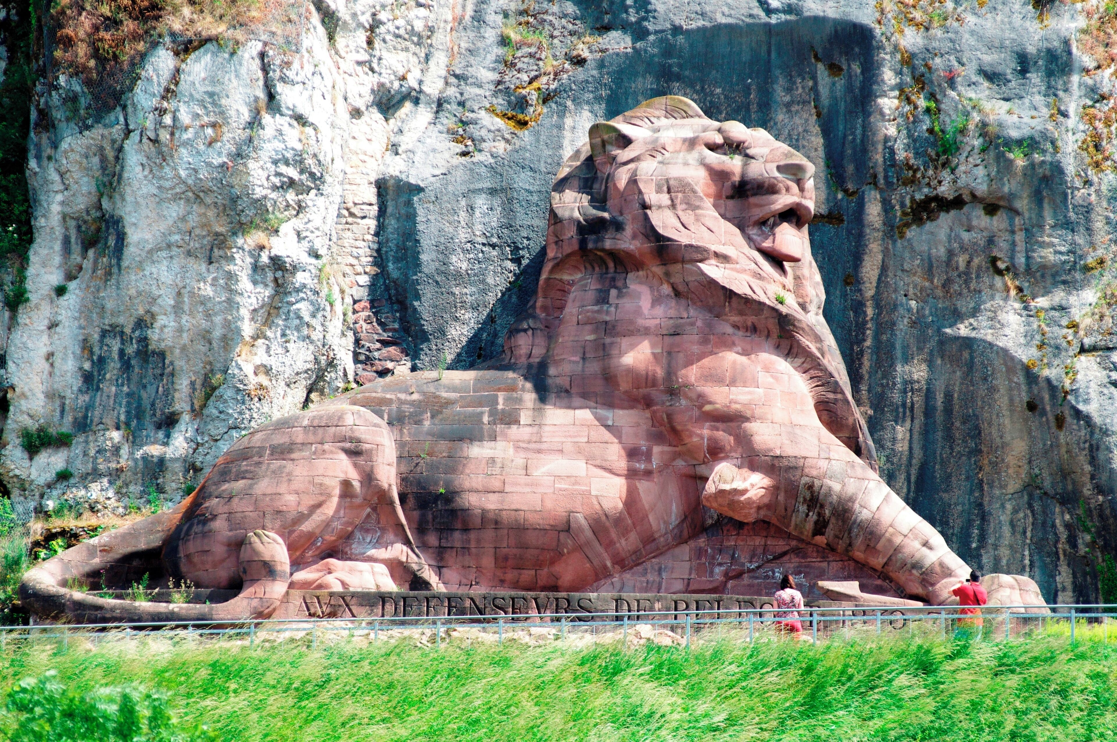 A large lion statue carved into a cliff.