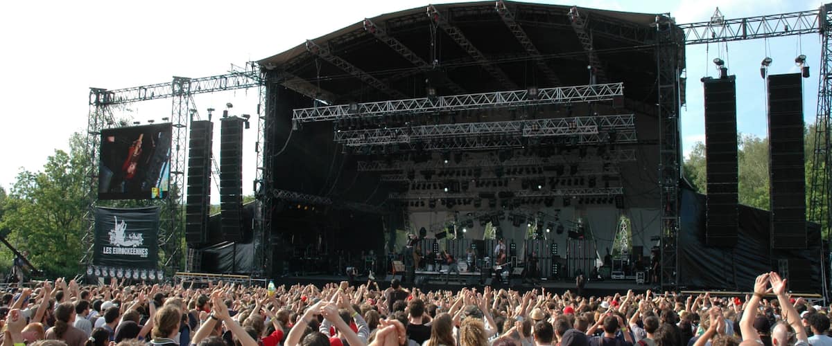 A large outdoor concert with a stage and a crowd of people.