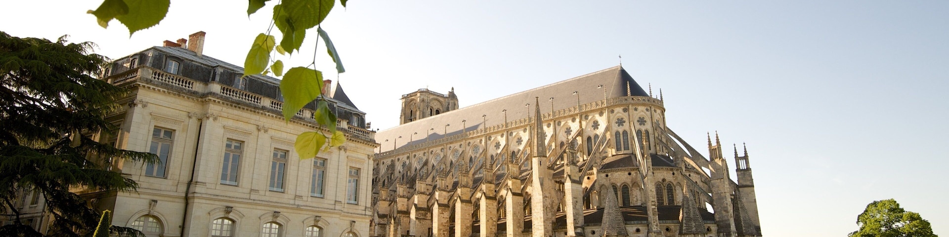 A historic building with intricate architecture and a well-maintained garden.