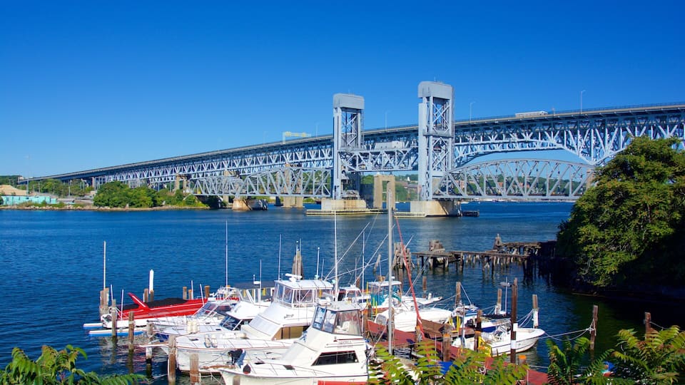 A bridge over a river with boats docked at the marina.