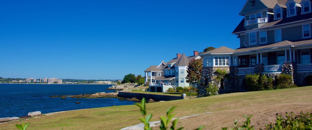 A waterfront property with a large house, a smaller house, and a stone structure.
