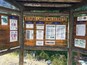 Ein Holzbalken mit verschiedenen Schildern und Hinweisen für die Alpine Lakes Wilderness, darunter die Pflicht zum Erwerb einer Freizeitkarte, Informationen zu Genehmigungen und örtliche Bestimmungen.