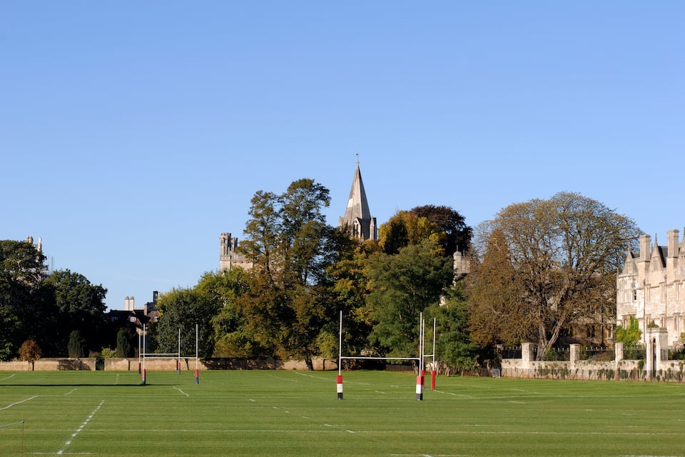A football field with goalposts and a church in the background.