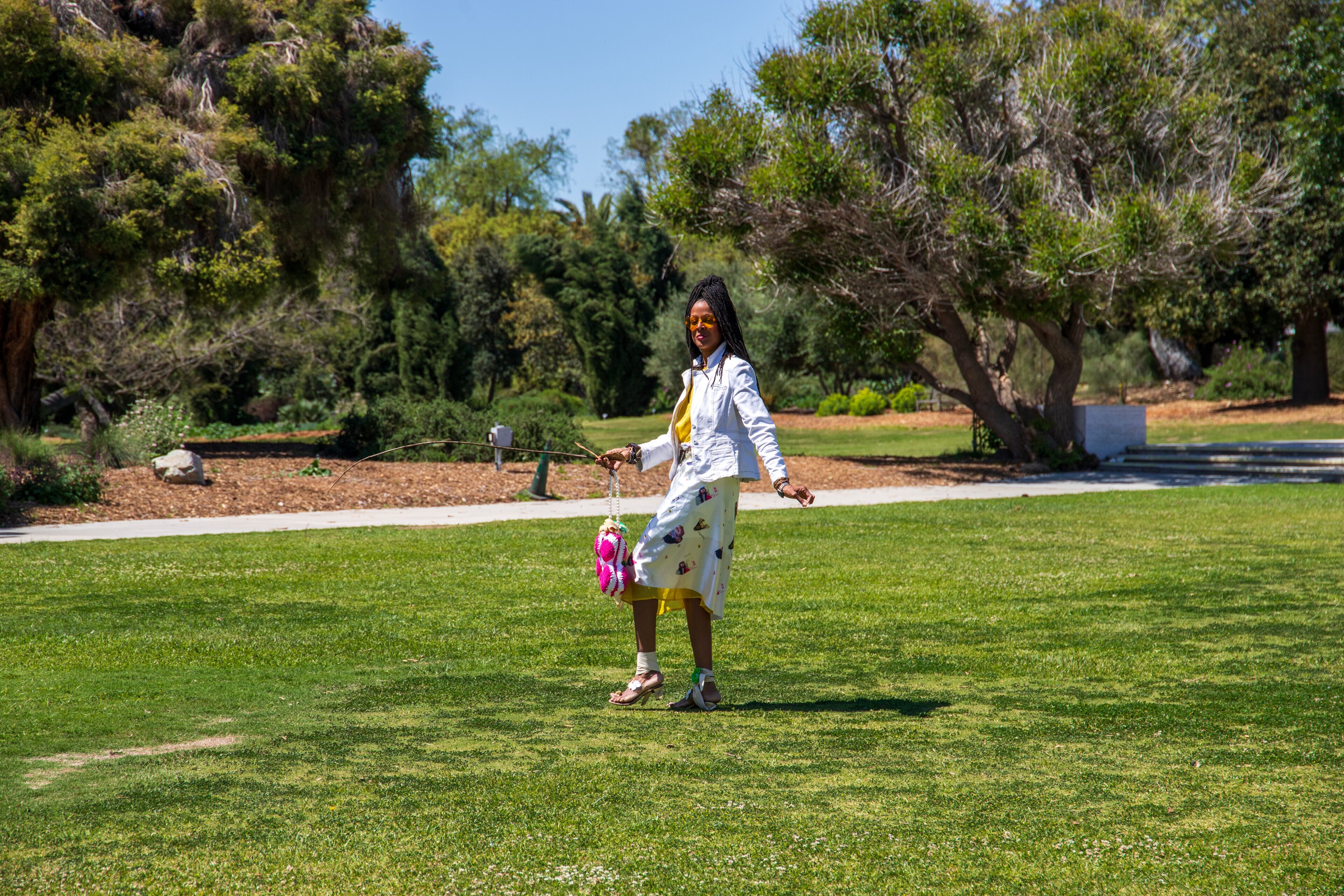 An African American woman with sister locks in a gorgeous landscape at the Los Angeles County Arboretum and Botanic Garden in Arcadia California USA