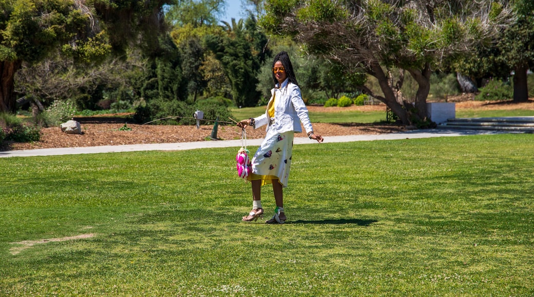 An African American woman with sister locks in a gorgeous landscape at the Los Angeles County Arboretum and Botanic Garden in Arcadia California USA