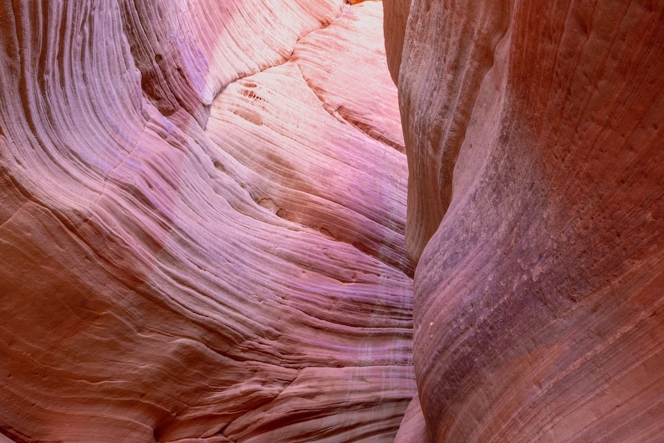 A narrow canyon with smooth, layered rock formations.