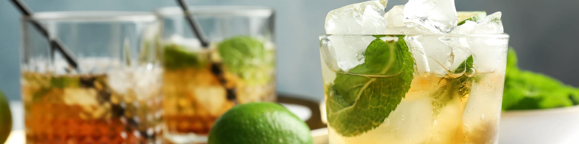 Glass of delicious mint julep cocktail on table