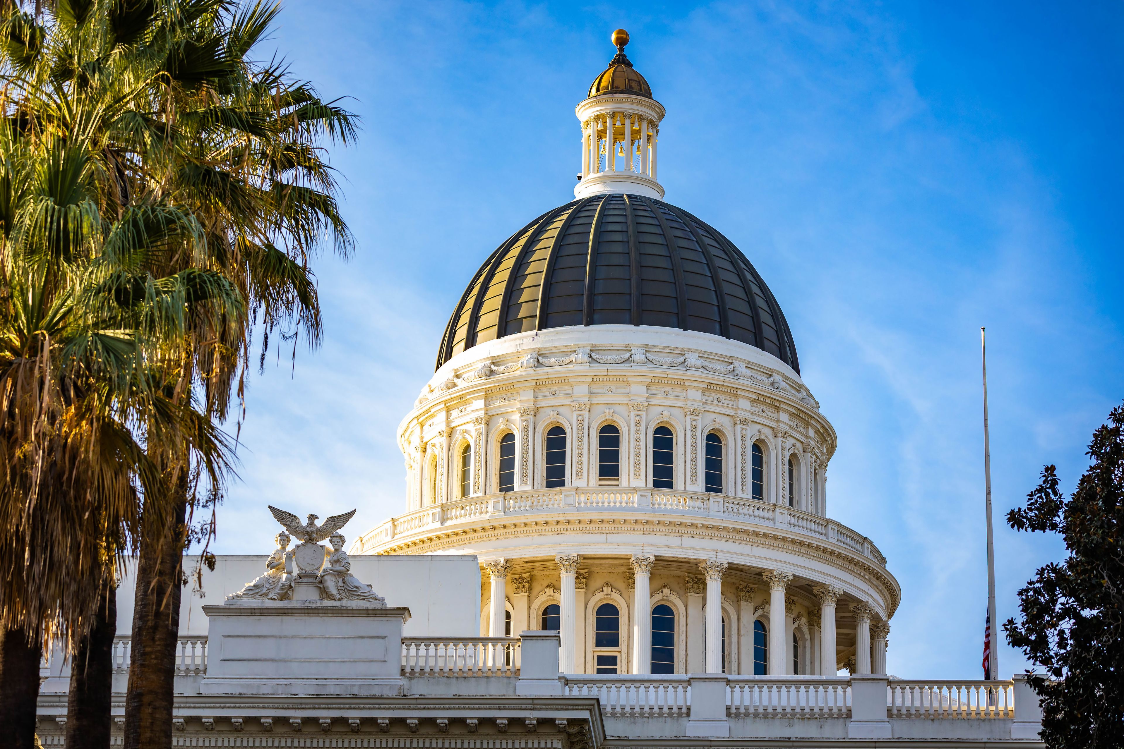 A large domed building with a golden dome and a statue on the front.