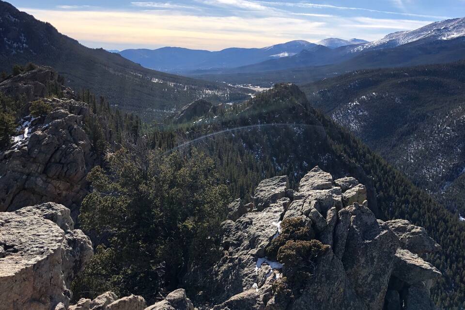 A mountainous landscape with rocky outcrops and snow-capped peaks.