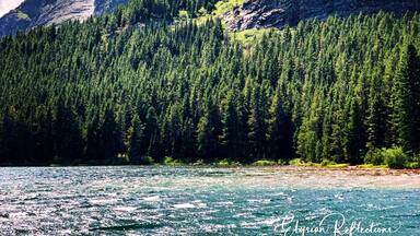 A mountain with a forested slope and a river in the foreground.