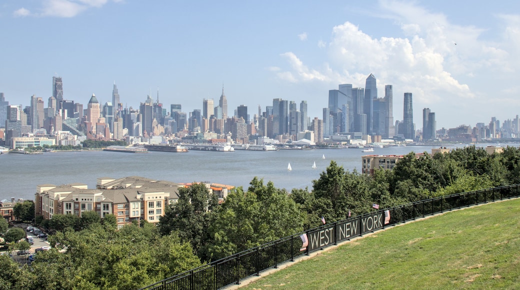 view of midtown manhattan skyline from a public park in west new york (city in jersey, nj, nyc) green space urban living hudson river blue sky clouds skyscraper cityscape high rise