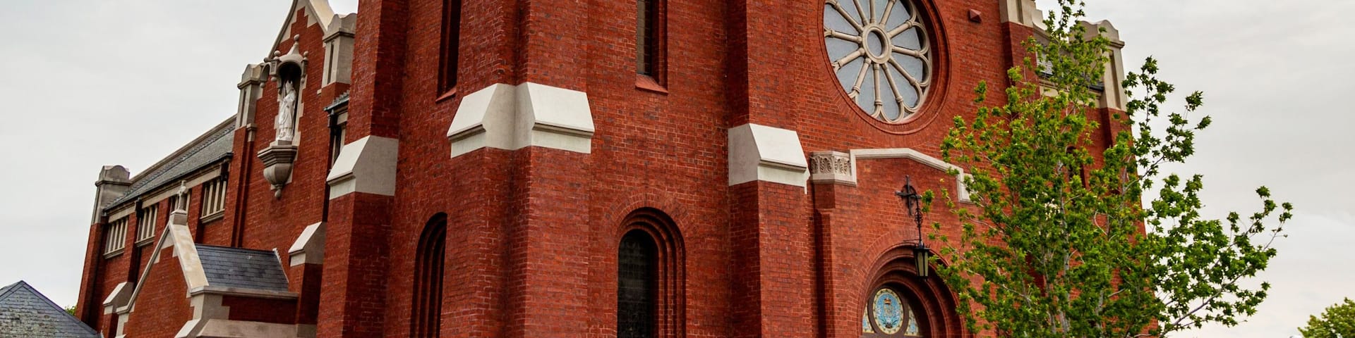 A red brick church with a clock tower and a dome.