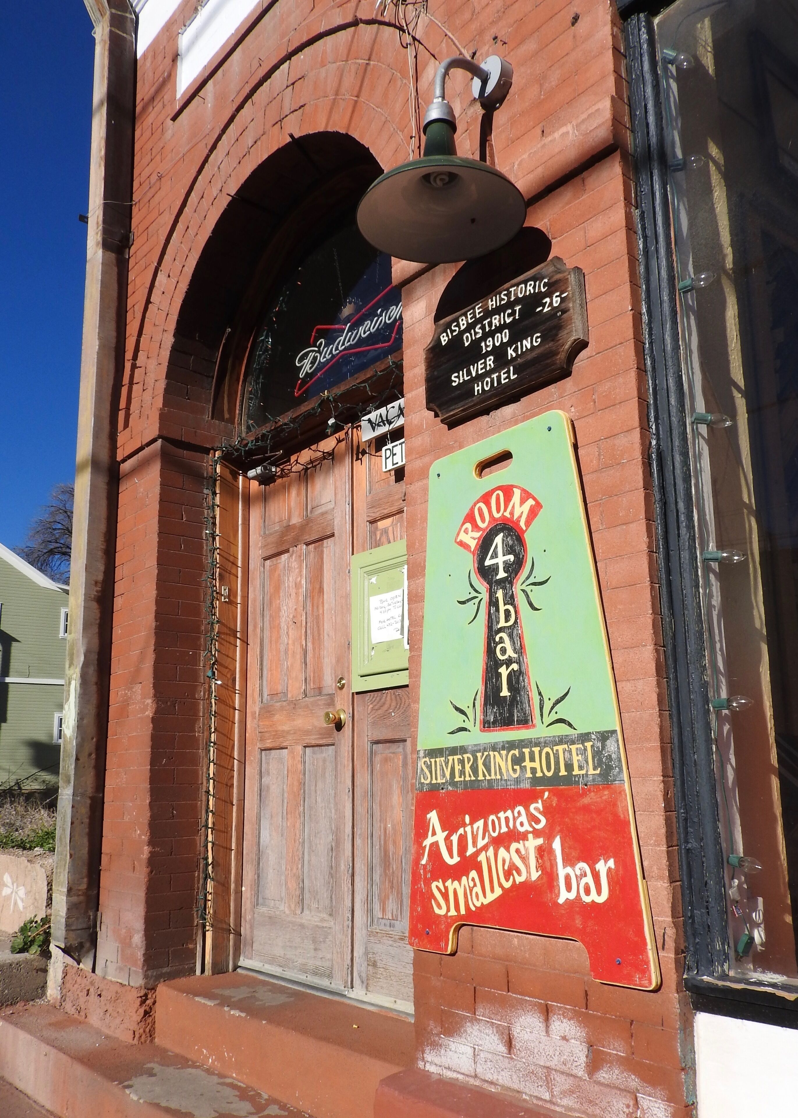 A historic building with a sign for the Silver King Hotel and a neon sign for Budweiser.
