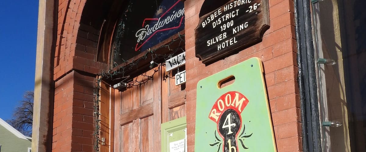 A historic building with a sign for the Silver King Hotel and a neon sign for Budweiser.