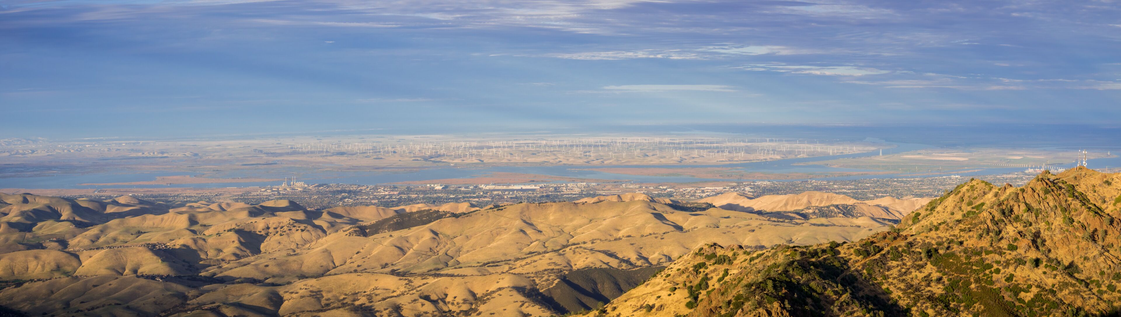 A mountainous landscape with a city in the distance.
