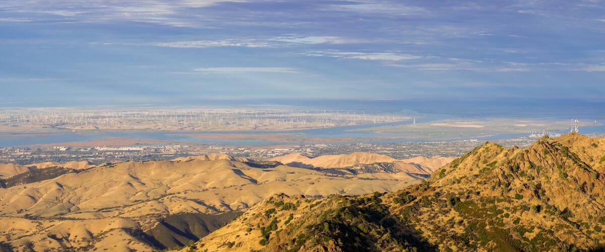 A mountainous landscape with a city in the distance.